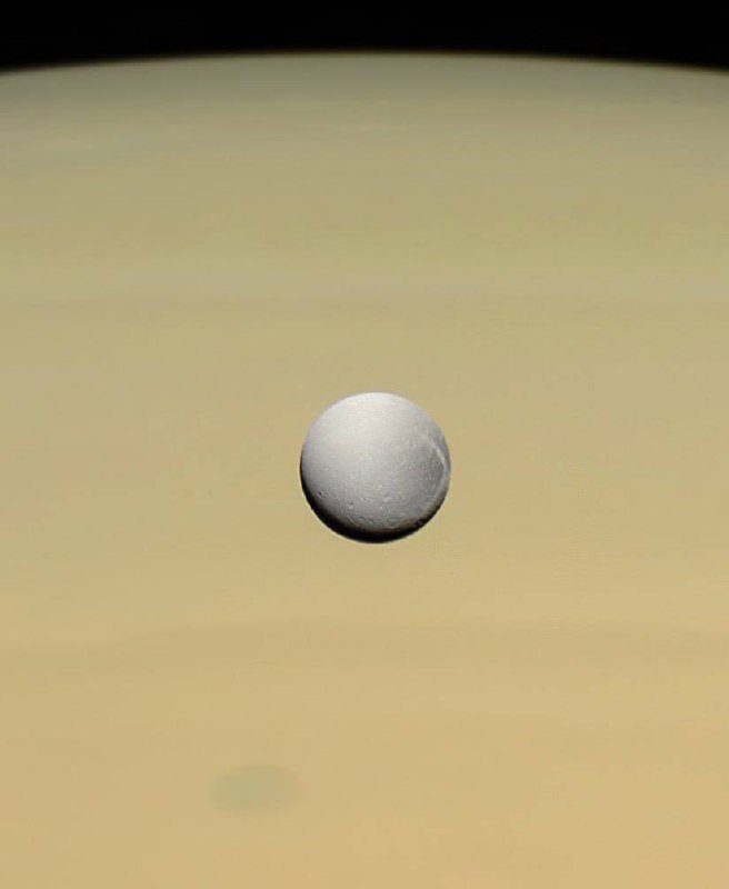 Saturn's moon Dione Shines Against Gas Giant's Atmosphere