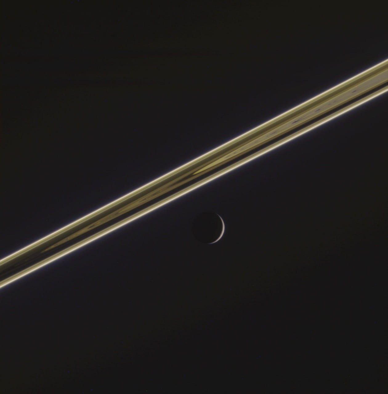 Dion's delicate scythe captured beneath Saturn's rings by Cassini spacecraft